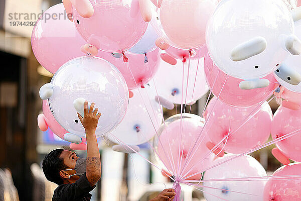 Mann verkauft rosa Luftballonspielzeug auf der Straße  Ho-Chi-Minh-Stadt  Vietnam  Indochina  Südostasien  Asien