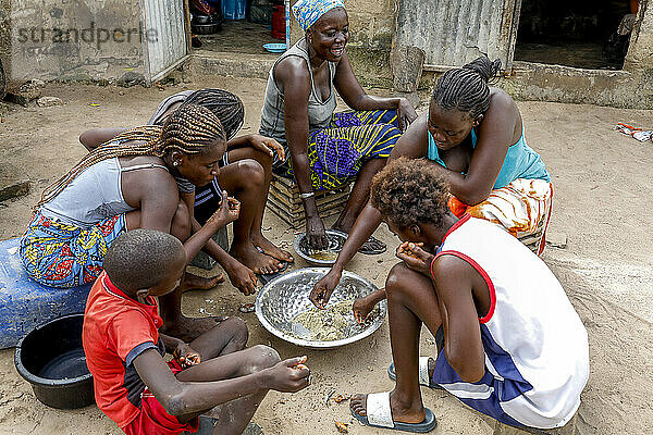 Familie beim Essen in einem Dorf in der Nähe von Fatick  Senegal  Westafrika  Afrika