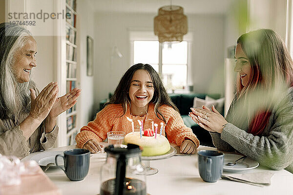 Fröhliches Mädchen genießt und feiert Geburtstag mit der Familie zu Hause