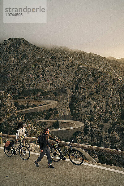 Männliche und weibliche Freunde radeln Fahrrad und erkunden die Natur im Urlaub