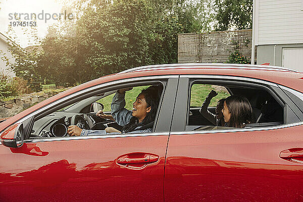Fröhliche Familie genießt den Roadtrip im Elektroauto
