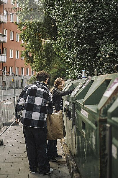 Mädchen entsorgt Müll mit jugendlichem Freund auf Fußweg