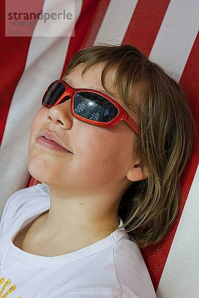 Junges Mädchen mit Sonnenbrille im Strandkorb  Sonne  Schutz  geschützt  UV-Strahlung