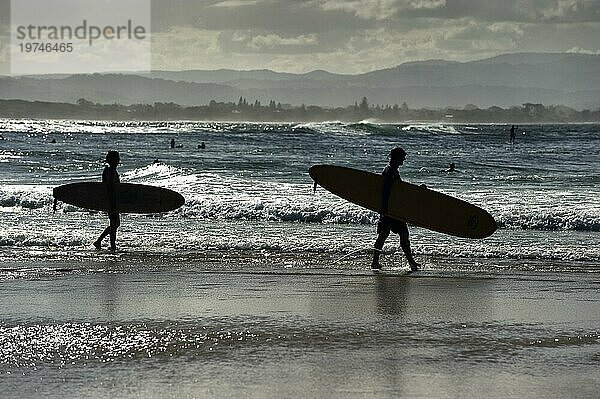 Surfer als Silhouette am Strand von Byron bay  Wassersport  Freizeit  bekannter Urlaubsort  Surfspot an der Ostküste  Queensland  Australien  Ozeanien