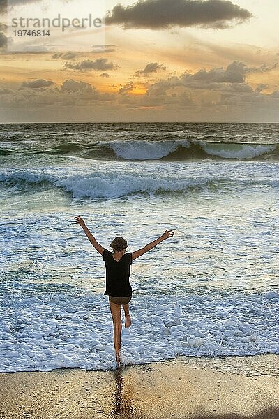 Mädchen am Strand der Nordsee mit Wellen in der Abendsonne  Meer  Wasser  Tourismus  Urlaub  Sommerurlaub  Spaß  Freude  Emotion  Sylt  Deutschland  Europa