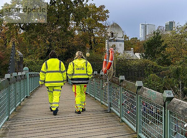 Zwei Personen in gelber Schutzkleidung  Brücke im Tiergartenpark  Berlin  Deutschland  Europa