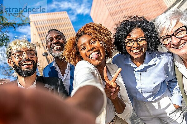 Frontalansicht von fröhlichen multiethnischen Geschäftsleuten  die Erfolg gestikulieren und ein Selfie im Freien machen