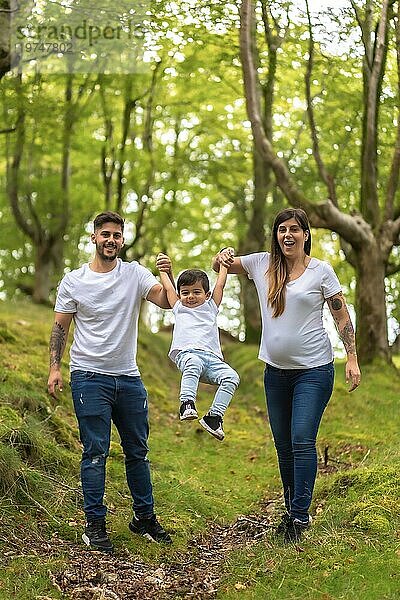 Vertikales Foto einer spielenden Familie bei einem Spaziergang durch einen Wald