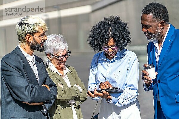 Selektiver Fokus auf eine Gruppe multiethnischer Geschäftsleute  die bei einem Treffen im Freien ein digitales Tablet benutzen