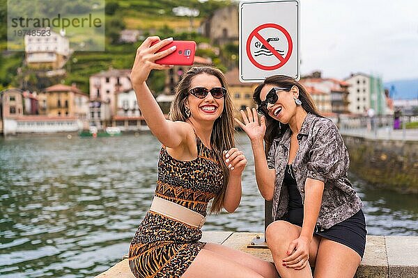 Freunde  die Spaß daran haben  ein Selfie neben einem Verbotsschild in einer Promenade zu machen