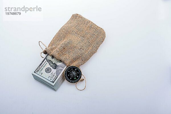 Kompass und Bündel von US Dollarin einem Sack auf einem weißen Hintergrund