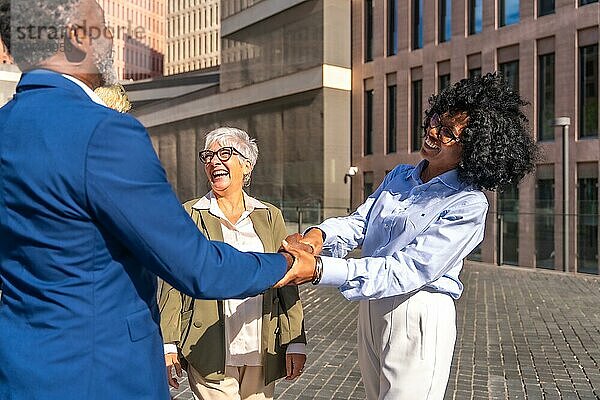 Afrikanische Geschäftsleute schütteln sich die Hände  wenn sie sich im Freien mit anderen Menschen treffen