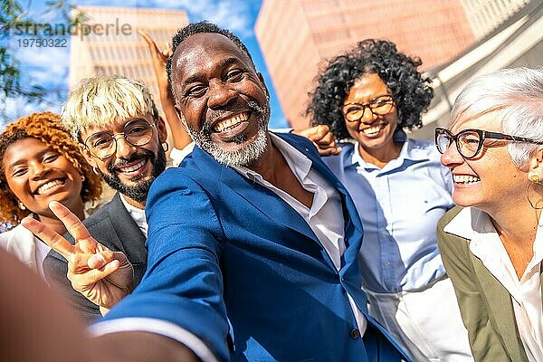 Frontalansicht eines glücklichen  eleganten afrikanischen Geschäftsmannes  der ein Selfie mit seinen Mitarbeitern macht