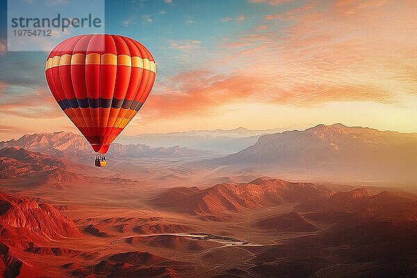 Eine bunte Heißluftballon schwebt in Himmel über einer Wüste Berglandschaft bei Sonnenuntergang mit orange und blaün Himmel im Hintergrund. Reise Reise Abenteuer Schönheit der Natur Konzept