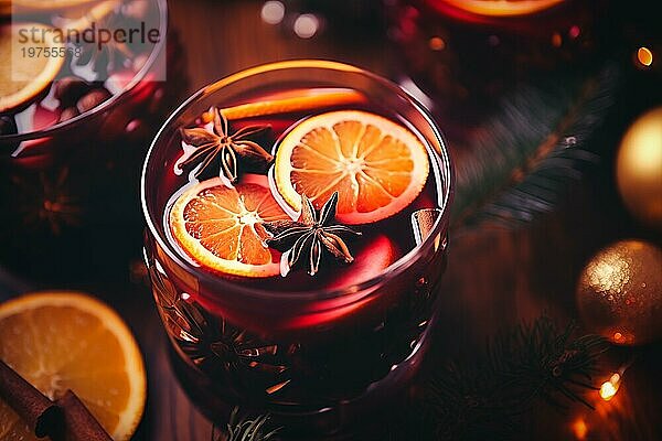 Ein Glas traditioneller Glühwein mit orangen und Preiselbeergarnituren auf einem gemütlichen Weihnachtstisch. Der Hintergrund ist unscharf mit Bokeh Lichtern und Kerzen  die eine warme und festliche Atmosphäre schaffen