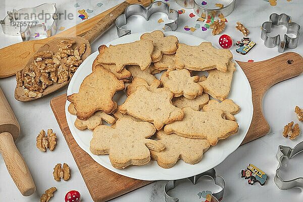 Gebackene Kekse für Neujahr in Form von Kleeblättern und Schweinchen auf weißem Te  Backzubehör