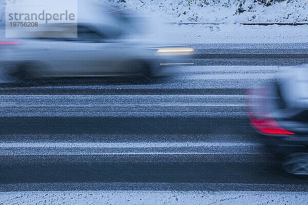 Verschneite Fahrbahn und verwischte fahrende Autos bei Morgendämmerung  Straße  Draufsicht  Deutschland  Europa