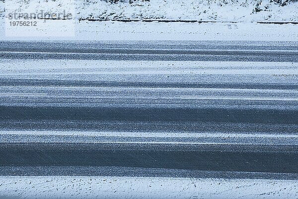 Verschneite Fahrbahn bei Morgendämmerung  Straße  Draufsicht  Deutschland  Europa