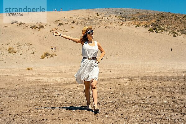 Glückliche Frau  die entlang einer Sanddüne gegen den blauen Himmel in Cabo de Gata  Spanien  läuft  Europa