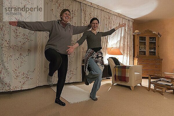 Zwei junge Frauen tanzen im Wohnzimmer  Franken  Bayern  Deutschland  Europa