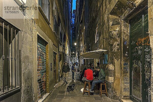 Abendliche Altstadtszene mit Anwohnern und einem Straßenhändler  Genua  Italien  Europa