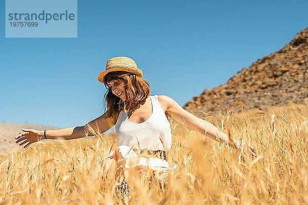 Frau genießt Freiheit und Natur in einem trockenen Weizenfeld in Cabo de Gata  Spanien  Europa