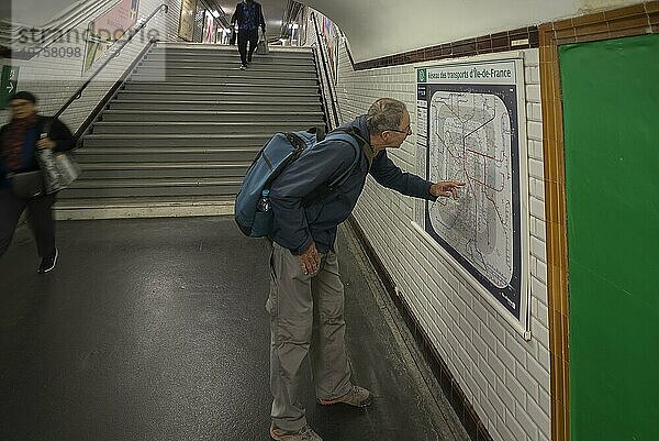 älterer Herr orientiert sich am Plan in der Métro  Paris  Frankreich  Europa