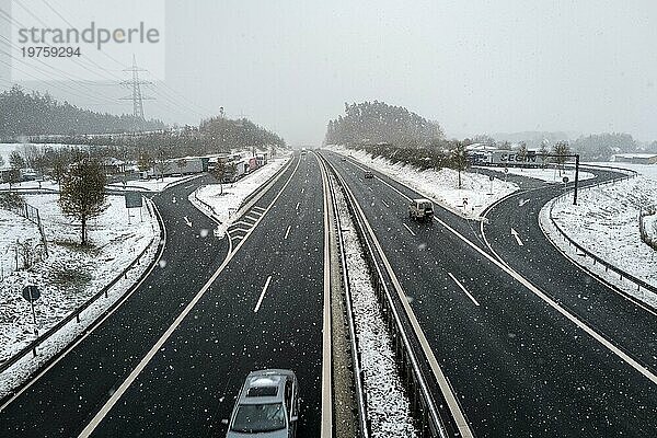 Autos fahren im Winter unter einer Fußgängerbrücke  da der Schnee schwierige Verkehrsbedingungen verursacht. Coburg  Deutschland  Europa