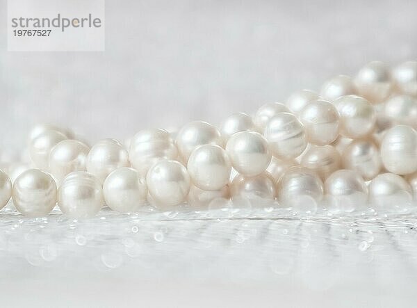 Natur weiße Perlenkette auf einem glitzernden Hintergrund in weichen Fokus  mit Highlights