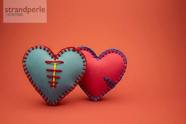 Hand genäht Schaumstoff Blatt blau und rosa Spielzeug Herzen über einen roten Hintergrund für romantische  Beziehung  Valentinstag  gebrochenes Herz Liebe Konzept