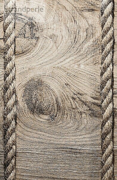 Vintage spiralförmig gedrehte Jutekabel auf Holzbrett vertikale Version
