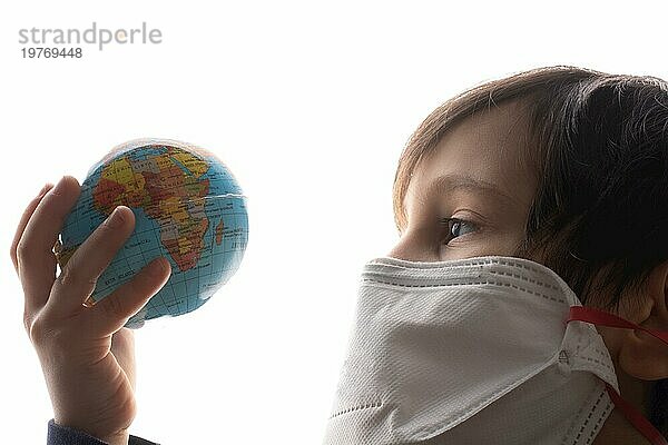 Junge hält einen Globus vor weißem Hintergrund. Nettes glückliches Kind  positives Gesicht