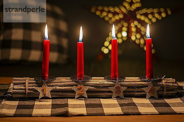 Advent Holzstäbchen Kerzenhalter mit silbernen Sternen mit Zahlen 1  2  3  4. Vier brennende rote Kerzen. Weihnachtsdekoration