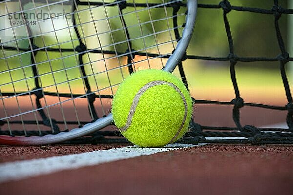 Tennisszene mit schwarzem Netz  Ball auf weißer Linie und Schläger in Tiefwinkelansicht und selektivem Fokus