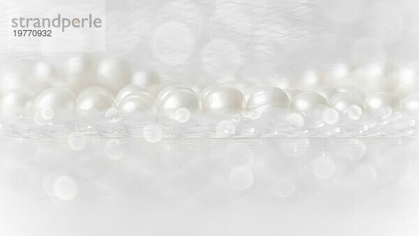 Natur weiße Perlenkette auf einem glitzernden Hintergrund in weichen Fokus  mit Highlights