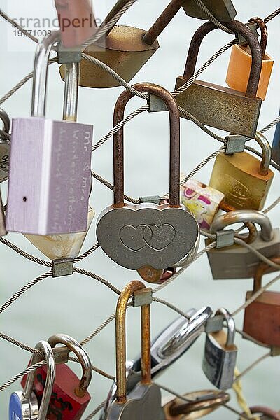 Liebe Vorhängeschlösser mit Herzform. Konzept der Liebe. Metallic Liebe Vorhängeschloss auf einer Brücke voll von Vorhängeschlössern