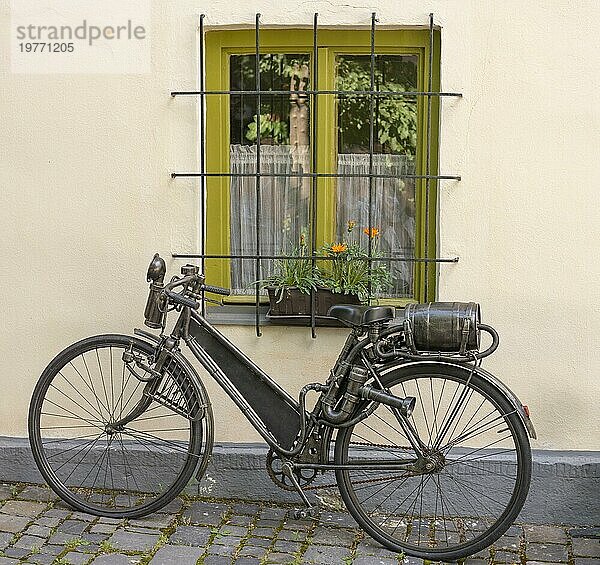 Ein altes  antikes Fahrrad mit Kraftstofftank in Form eines Weinfasses  das am Gepäckträger befestigt ist. Benzinbetriebenes Vintagefahrrad aus Metall. Nahaufnahme. Ausschnitt