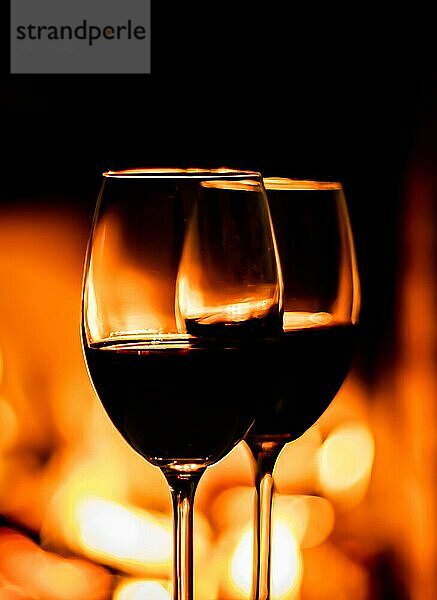 Zwei Gläser Rotwein auf dem Hintergrund der Kamin Lichter. Weihnachten Urlaub Konzept