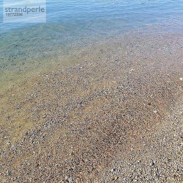 Schöne Hintergrund der blaün ruhigen Meer mit kleinen Fischen  Sand und Kieselsteinen. Ruhe und Entspannung an der Meeresküste