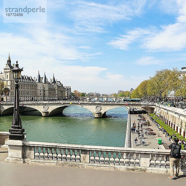 Frankreich  06. April 2019: Stadtbild von Paris und Saint Michel Brücke über die Seine. Ein Tourist fotografiert eine schöne Aussicht auf die Promenade mit Menschen  die sich an einem sonnigen Tag ausruhen  Europa