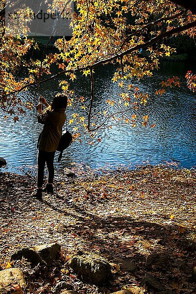 Junges Mädchen fotografiert am See in der Herbstzeit