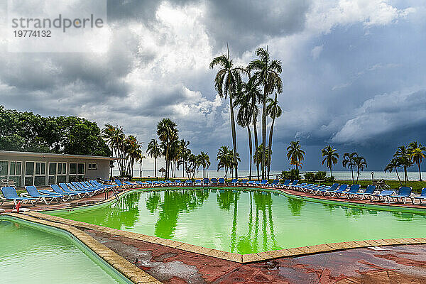 Grüner Pool in einem Luxushotel im Hotel el Colony vor einem Sturm  Isla de la Juventud (Insel der Jugend)  Kuba  Westindische Inseln  Mittelamerika