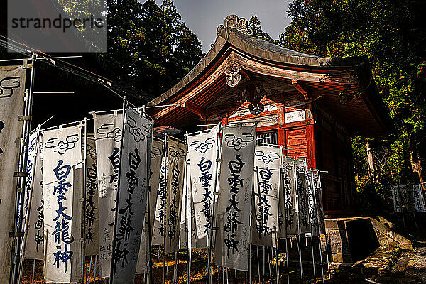 Weiße Banner mit darauf geschriebenen Kanji am Mount Iwaki-Schrein  in der Nähe von Hirosaki  Nord-Honshu  Japan  Asien