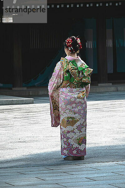 Ein Mädchen in traditioneller Kleidung von hinten in einem Tempel in Tokio  Tokio  Honshu  Japan  Asien
