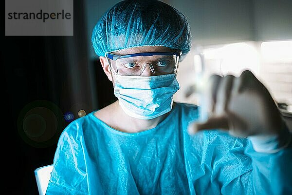 Junge männliche Chirurg Arzt in Uniform mit einer Spritze ist die Vorbereitung für die Injektion