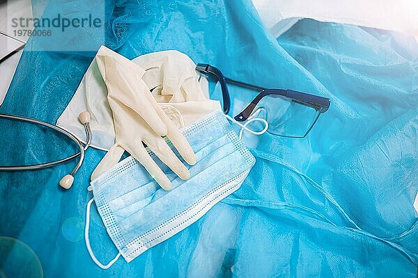 Medizinische Schutzausrüstung für Arzt  medizinische Handschuhe  Gesichtsschutz  Brille und Maske auf einem blauen Hintergrund