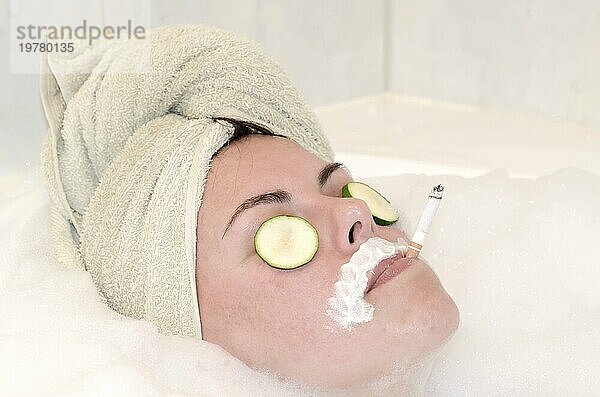 Headshot einer Frau  die sich in der Badewanne mit einem Handtuch auf dem Kopf entspannt und eine Zigarette in einem SPA in der Schweiz raucht