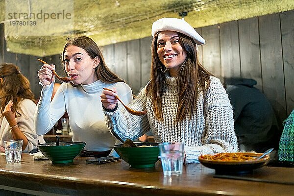 Kaukasische Freunde lächeln in die Kamera beim Essen in einem asiatischen Restaurant