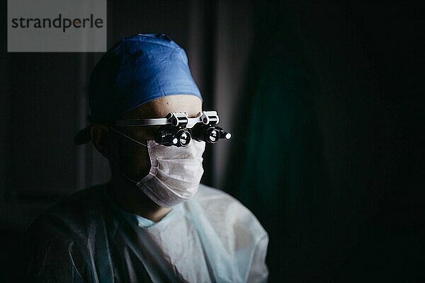 Neurochirurg führt eine Operation in einer medizinischen Klinik in einer Brille mit Nahaufnahmegläsern durch
