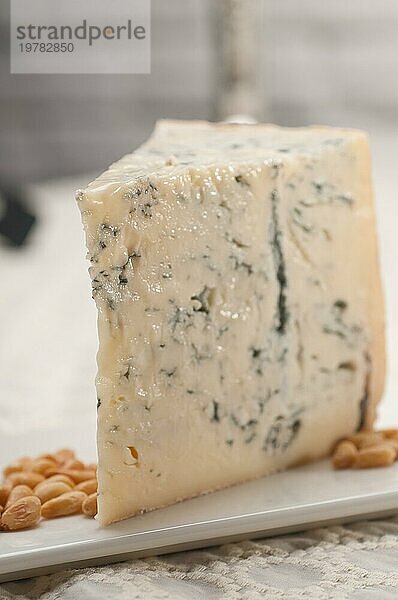 Ein Stück italienischer Gorgonzolakäse frisch geschnitten  und Pinienkerne